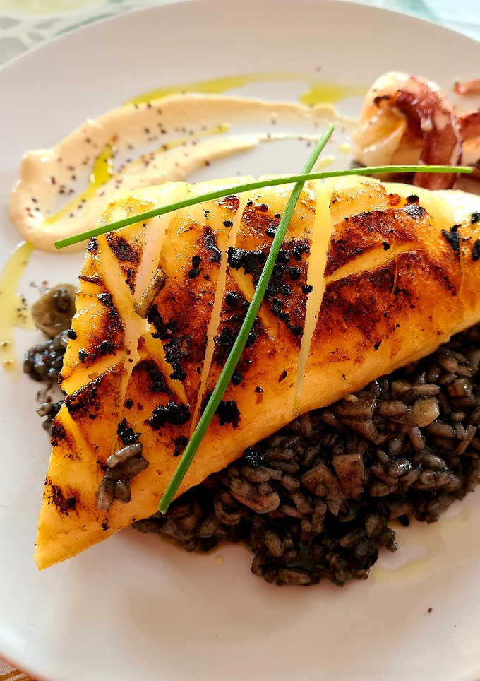 Una foto de Calamar de potera a la plancha sobre risotto nero y alioli