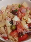 Insalata di pasta, con pomodori, olive miste, mozzarella, prosciutto cotto, tonno, basilico