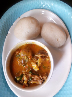 A picture of Goat meat native soup with fufu.