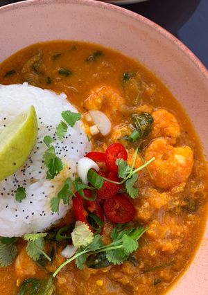 A picture of Thai red prawn curry with sticky rice.