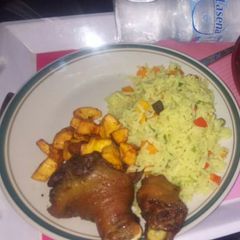A picture of Fried rice,plantain amd fried chicken.