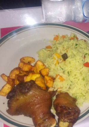 A picture of Fried rice,plantain amd fried chicken.