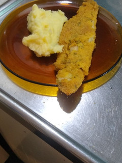 Una foto de Milanesa de merluza con puré de papa