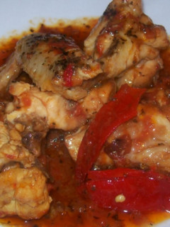 Una foto de Pollo con tomate y pimientos rojos