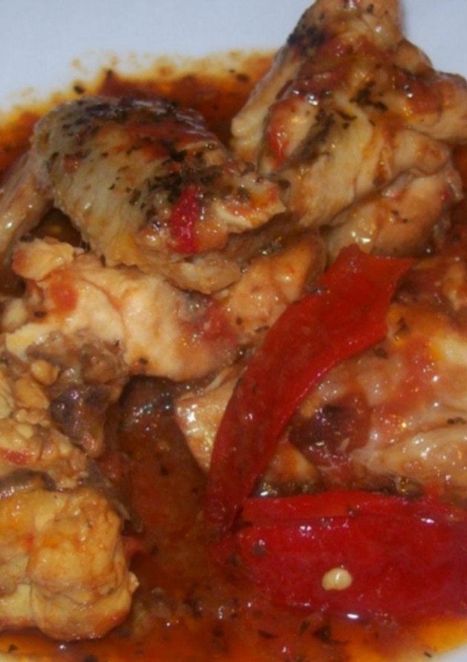 Una foto de Pollo con tomate y pimientos rojos