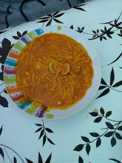 Una foto de Fideos amarillos con gambas y almejas