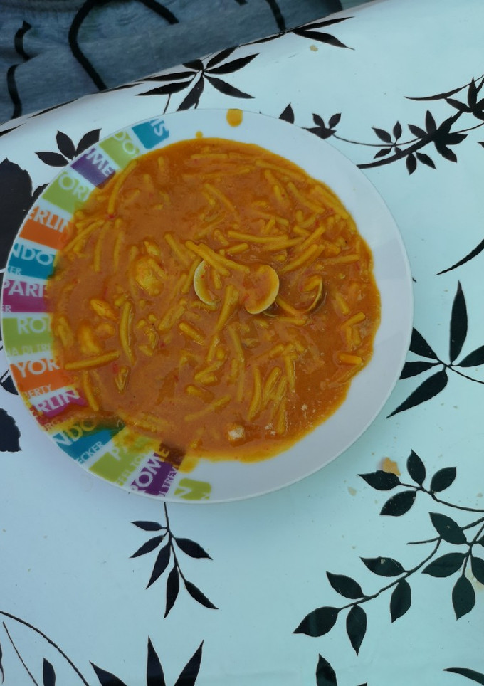 Una foto de Fideos amarillos con gambas y almejas