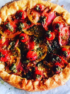 Una foto de Gallette de harina de espelta integral de tomates con pesto de albahaca, rúcula y almendras