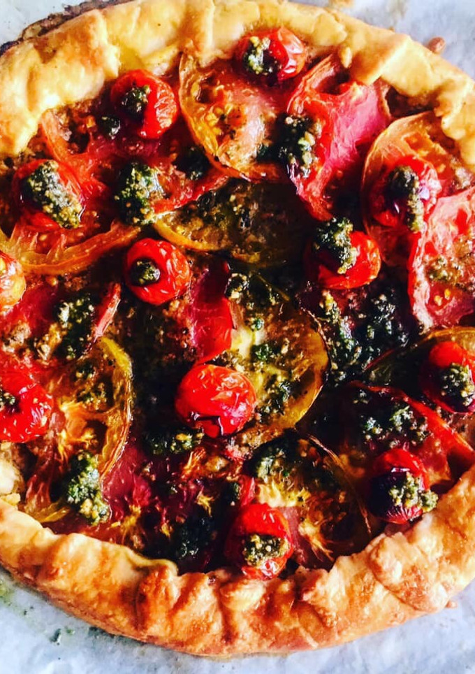 Una foto de Gallette de harina de espelta integral de tomates con pesto de albahaca, rúcula y almendras