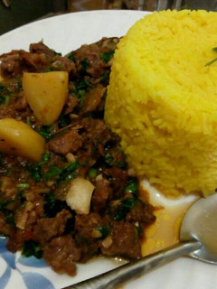 A picture of Tumeric rice served with beef stew.