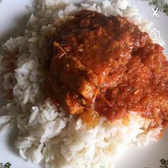 A picture of White rice with tomato stew.