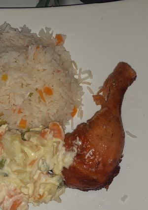 Una foto de Pollo dorado con arroz y ensalada rusa😋😋😋
