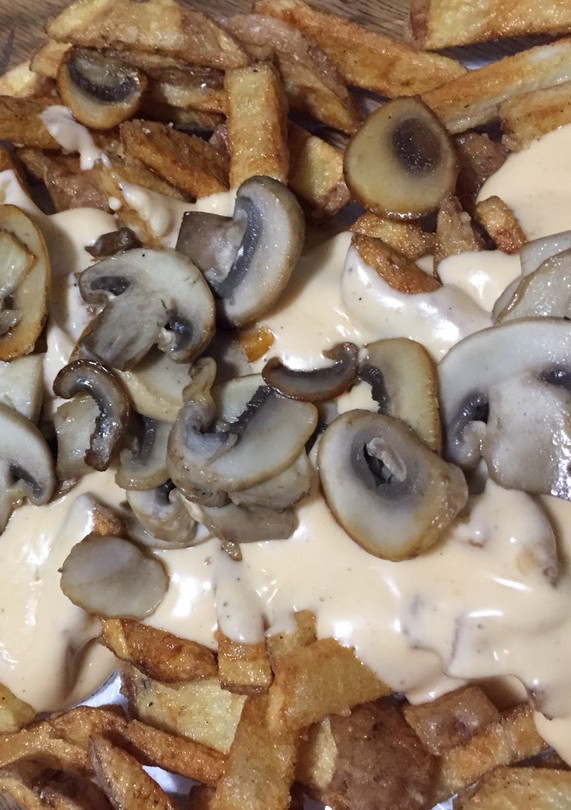 Una foto de Papas fritas con salsa de queso cheddar 🧀