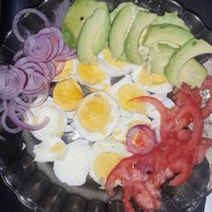 A picture of Boiled eggs served with kachumbari and avocado.