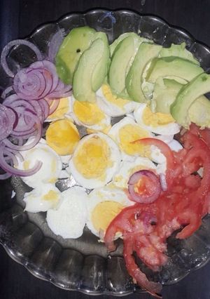 A picture of Boiled eggs served with kachumbari and avocado.
