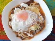 Una foto de chilaquiles con maíz
