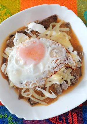 Una foto de Chilaquiles con tortilla azul