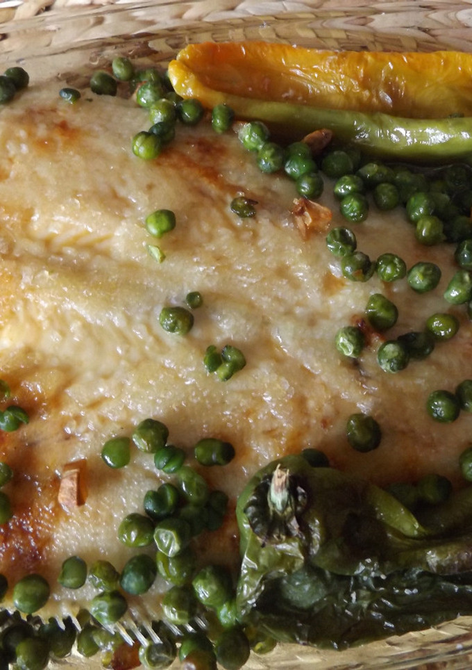 Una foto de Gallo al ajo con guisantes y pimientos verdes