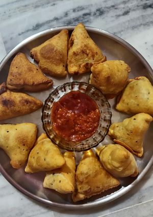 A picture of Samosa with spicy red chutney.