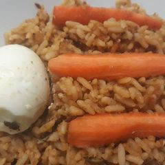 A picture of Jollof rice with carrots and egg.