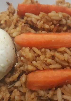 A picture of Jollof rice with carrots and egg.