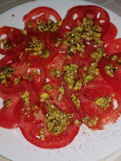 Una foto de Carpaccio de tomate con vinagreta de pistachos
