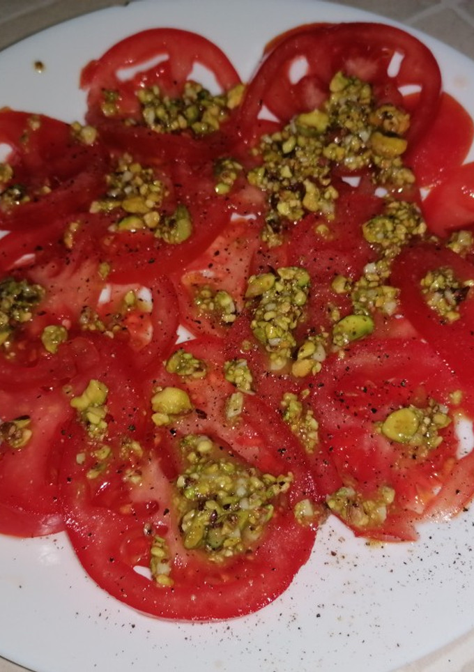 Una foto de Carpaccio de tomate con vinagreta de pistachos
