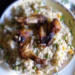 A picture of Coconut rice with chicken and veggies.