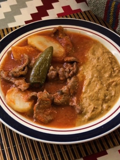 Una foto de Bistec con papas en salsa roja