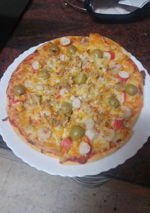 Una foto de Pizza de atún, gambas, palitos de cangrejo y aceitunas