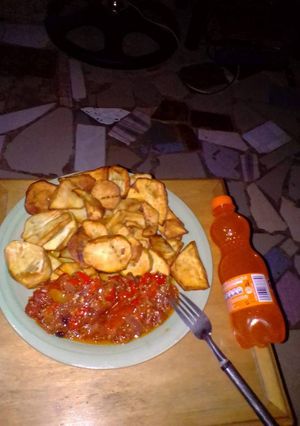 A picture of Fried potatoes with tomatoes sauce.