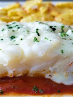 Una foto de Ventresca de bacalao en papillote con salsa de tomate y allioli de bacalao