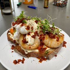 A picture of Scallops, nduja & poached duck eggs on sourdough with a mustard creme fraiche.