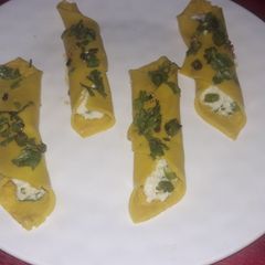 A picture of Khandvi cigar stuff with hung curd.