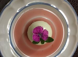 Una foto de Panna Cotta con coulis de Jamaica y tejocote acompañado de una bebida de Jamaiquila