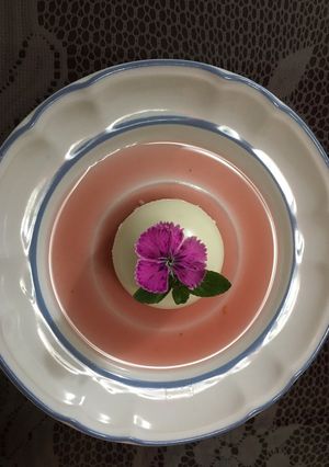 Una foto de Panna Cotta con coulis de Jamaica y tejocote acompañado de una bebida de Jamaiquila