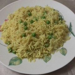 A picture of Yellow rice with green pea.