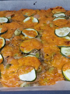 Una foto de Pizza casera de salmón al limón con calabacin y queso cheddar
