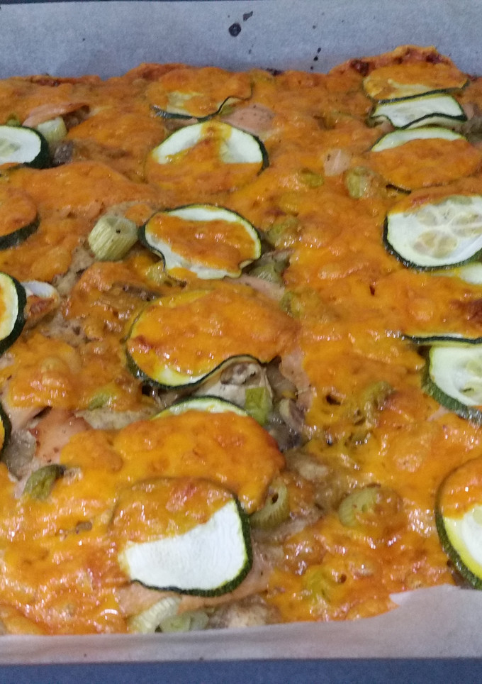Una foto de Pizza casera de salmón al limón con calabacin y queso cheddar