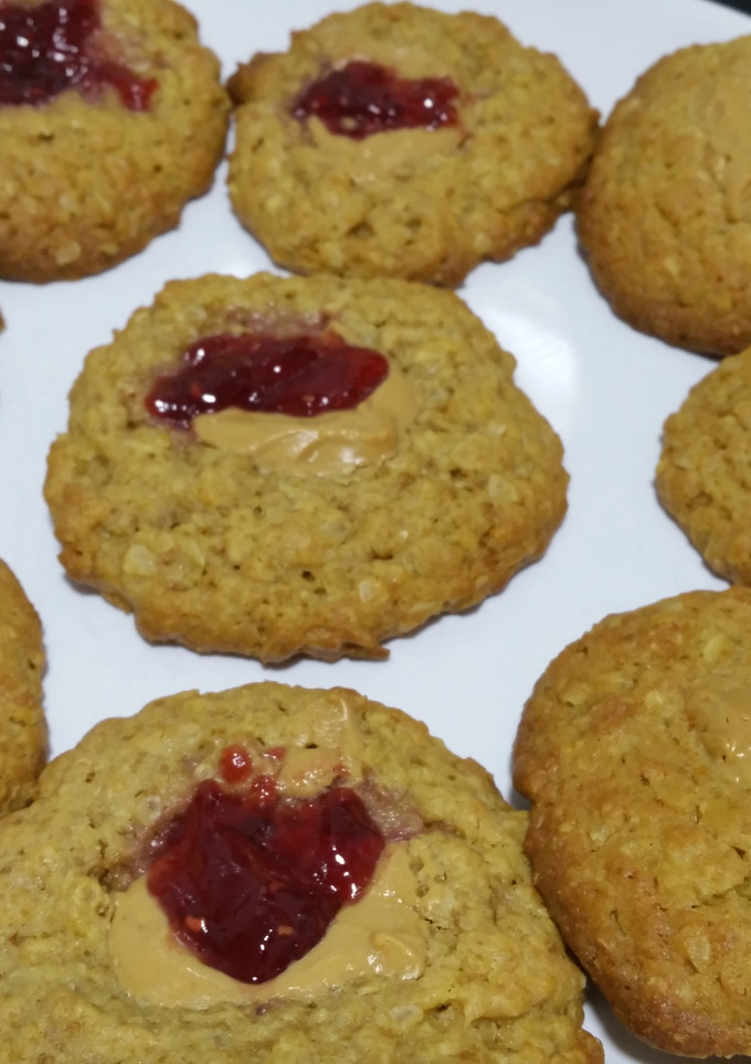 Una foto de Cookies de avena con aroma de limón, mermelada de frambuesa y crema de cacahuete