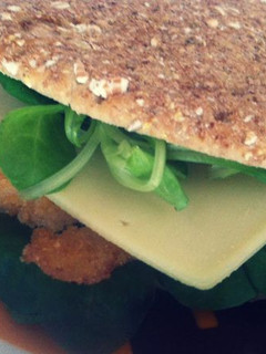 Una foto de Sandwich de pollo empanado con queso, canónigos y salsa césar