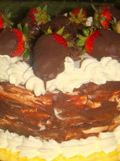 Una foto de Torta de chocolate con frutillas y crema chantillí