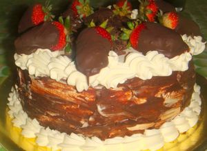 Una foto de Torta de chocolate con frutillas y crema chantillí