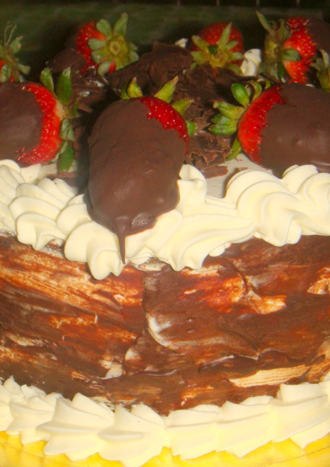 Una foto de Torta de chocolate con frutillas y crema chantillí
