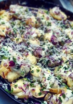 Una foto de Papas con queso y cebolla morada