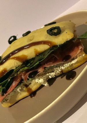 Una foto de Ciabatta con relleno de Queso de cabra con especias, jamón serrano, espinacas y crema de balsámico
