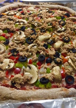 Foto principal de Pizza masa integral casera de atún, pimiento verde y rojo, cebolla, champiñones y olivas negras