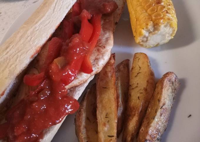 Spicy Cajun chicken with potato wedges and buttered corn