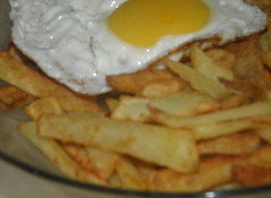 Una foto de Papas fritas con huevo frito 