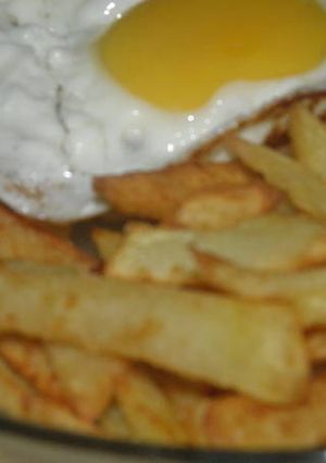 Una foto de Papas fritas con huevo frito 
